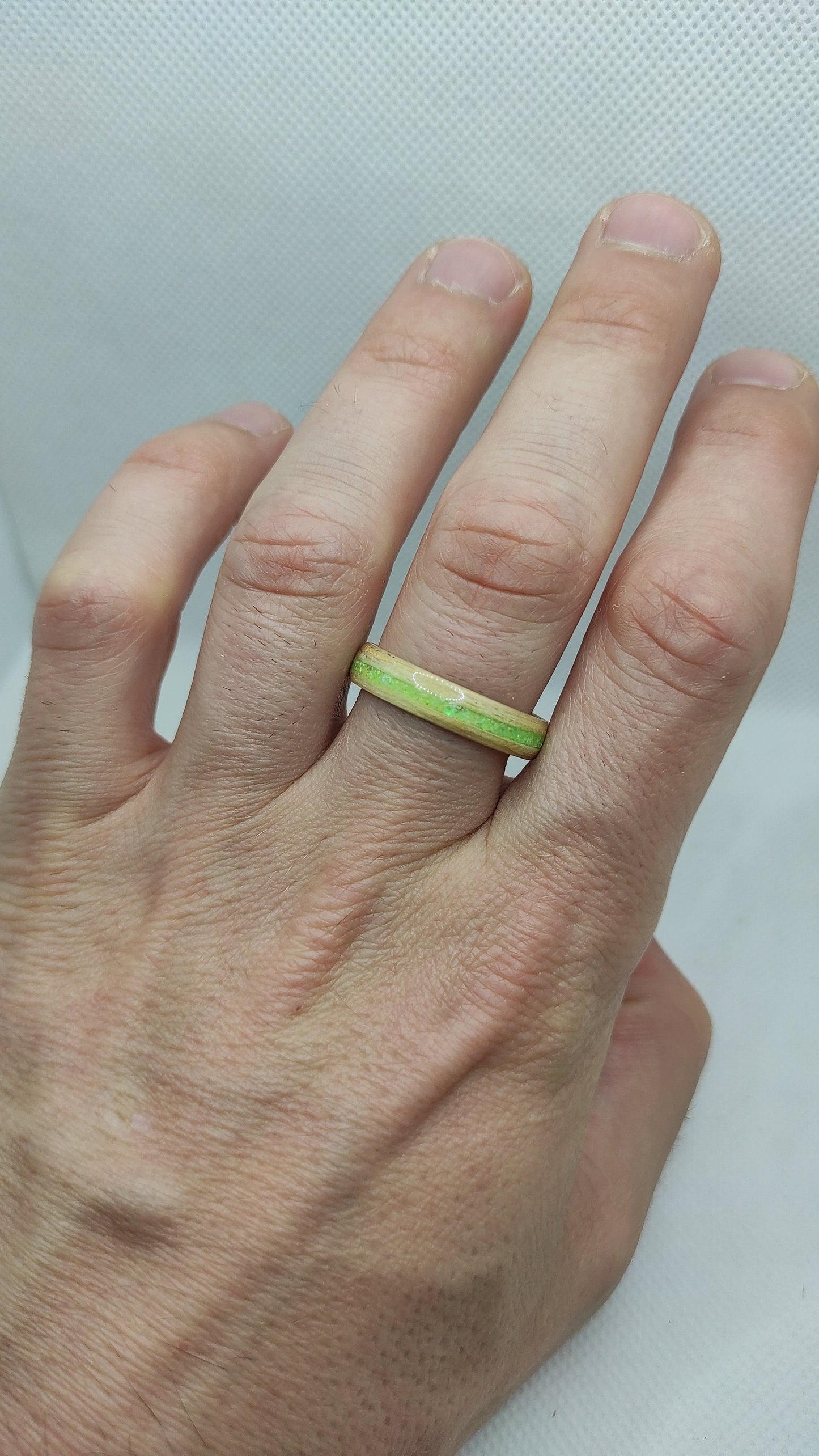 Close-up of handmade wooden ring with neon green glitter accent