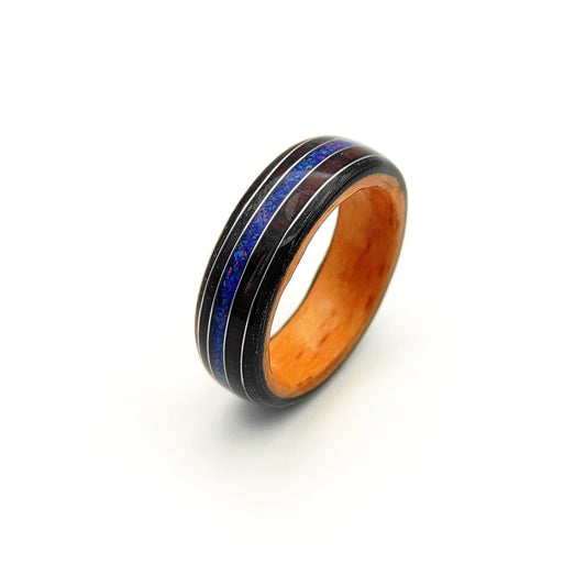 Close-up of black oak veneer ring with crushed blue opal and silver wire accents